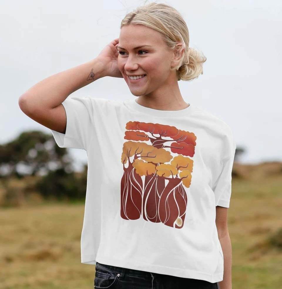 Woman wearing a white t-shirt with a design of Acacia trees